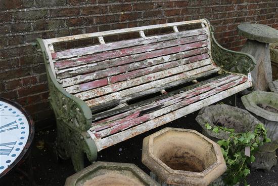 A garden bench with wrought iron scroll ends and slatted wood seat and back